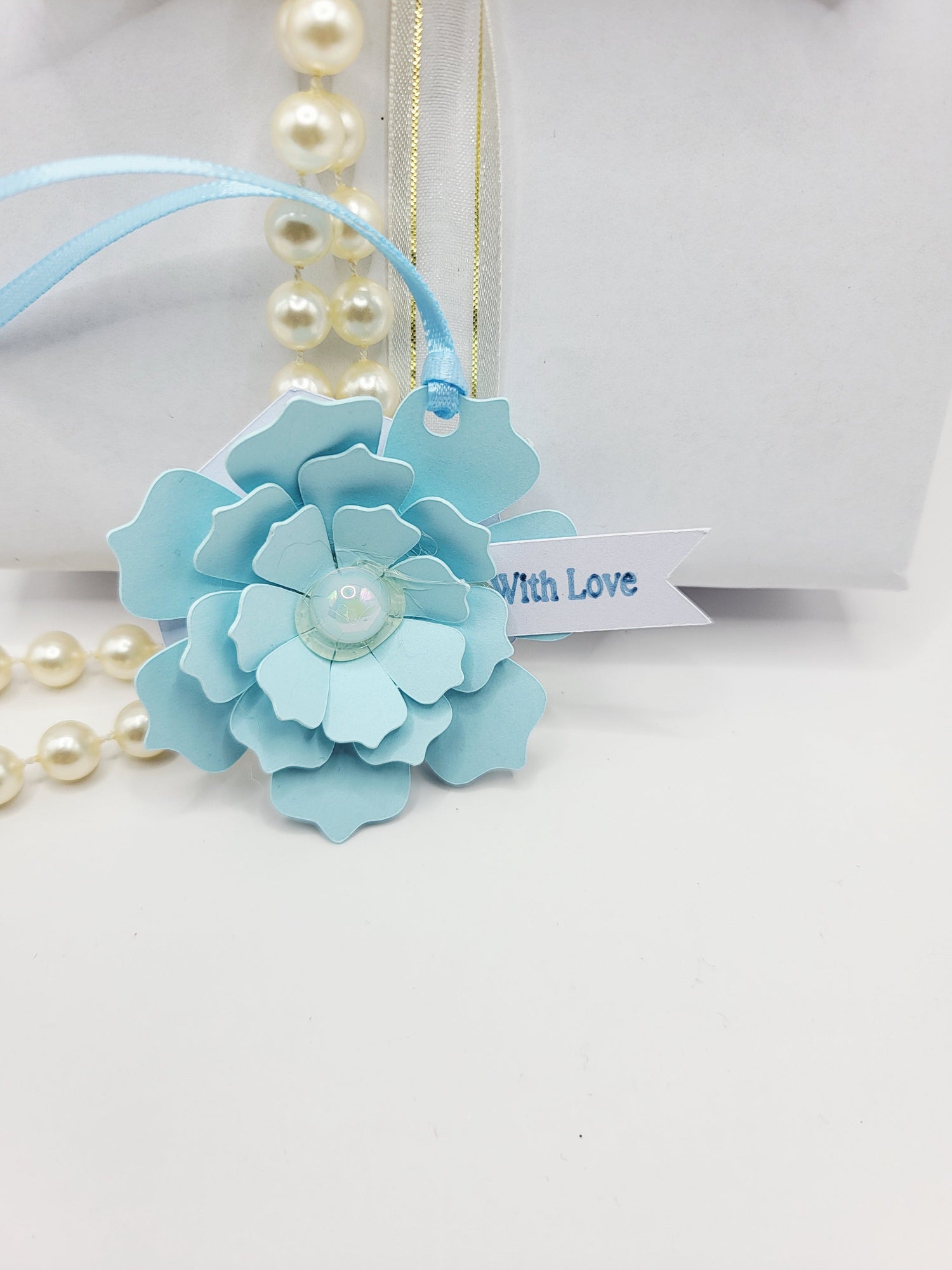 Blue 3d floral gift tag with a flat pearl centre and blue satin ribbon to attach to gift