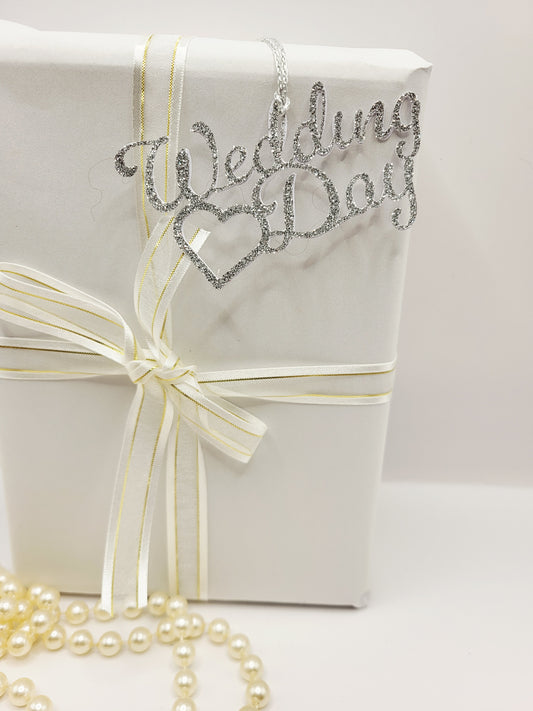 Silver glitter decorative gift tag. The tag says wedding day with a love at heart at one side. This tag is for decorative purpose only. You cannot write on it