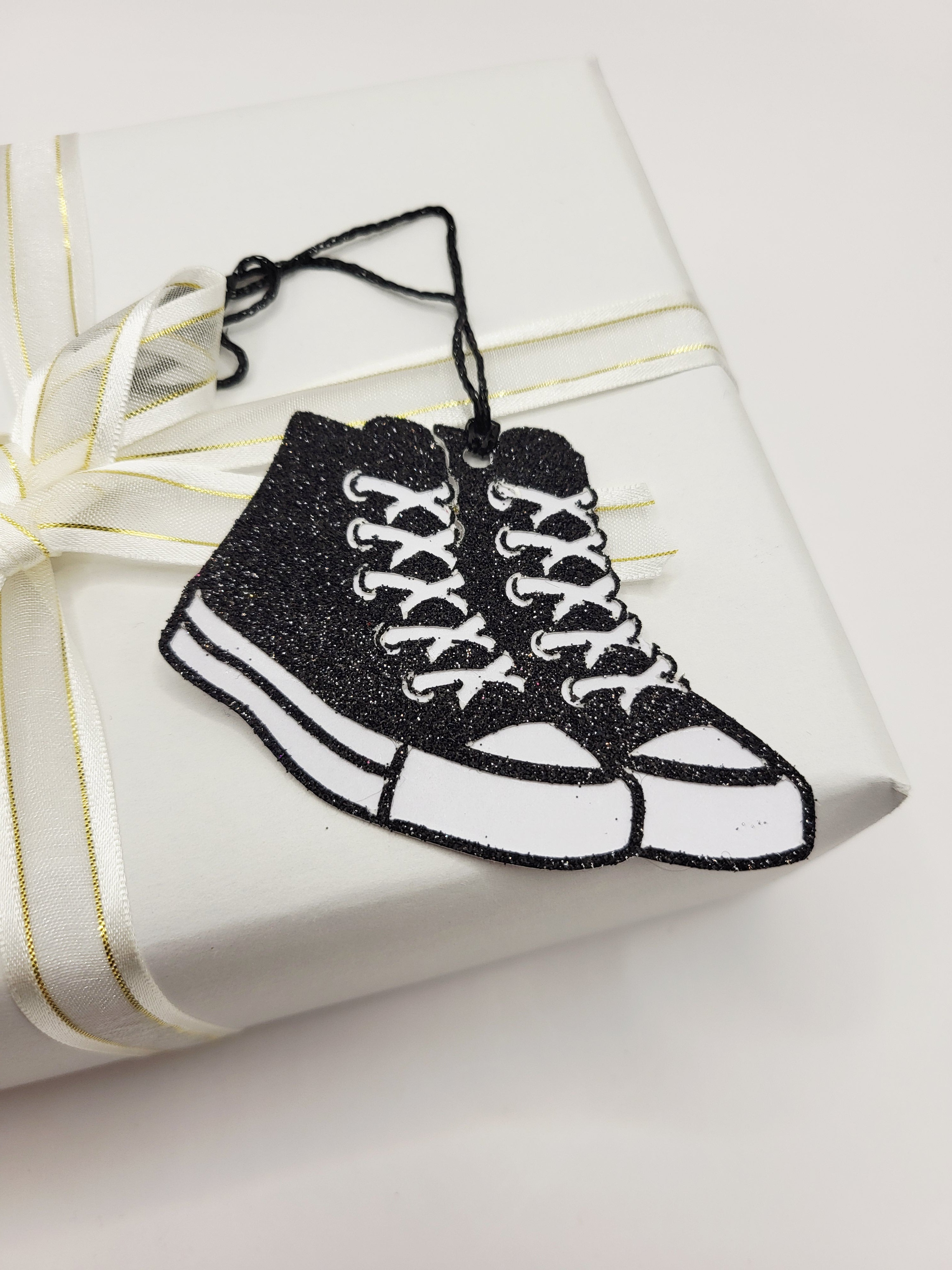 Black glitter baseball boots with a white background. \there is a black metallic cord to attach to your gift