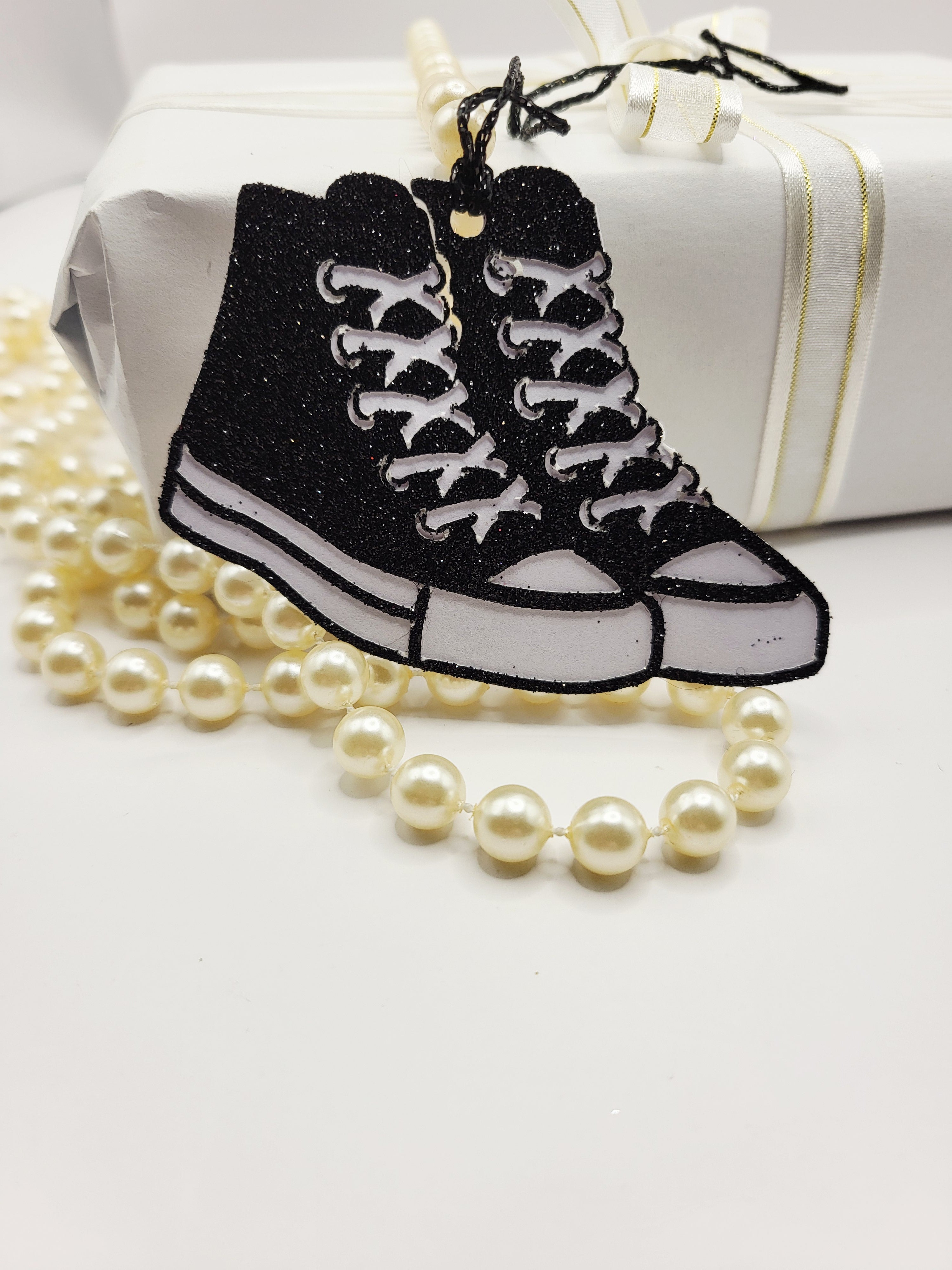 Black glitter baseball boots with a white background. \there is a black metallic cord to attach to your gift