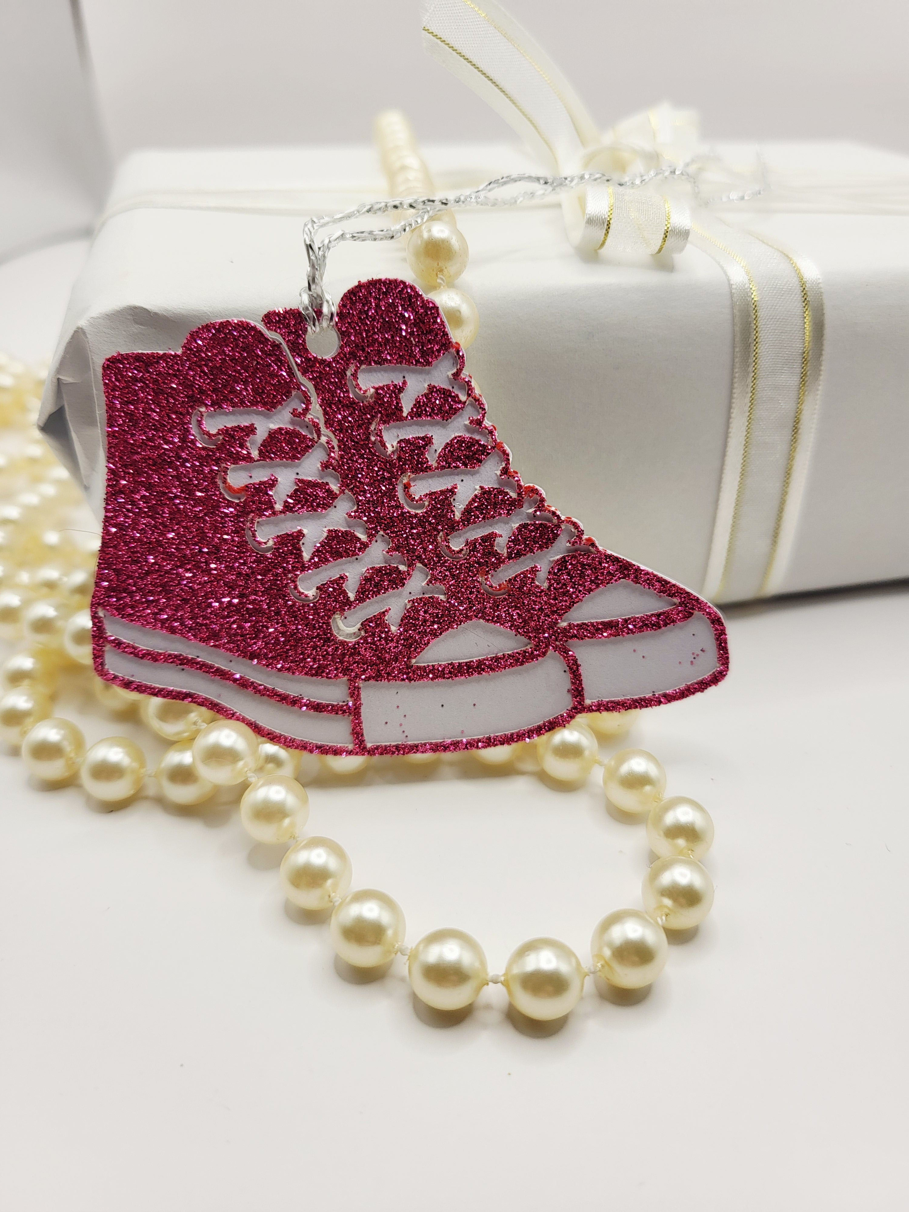 Pink glitter baseball boots with a white background. There is a silver metallic cord to attach to your gift