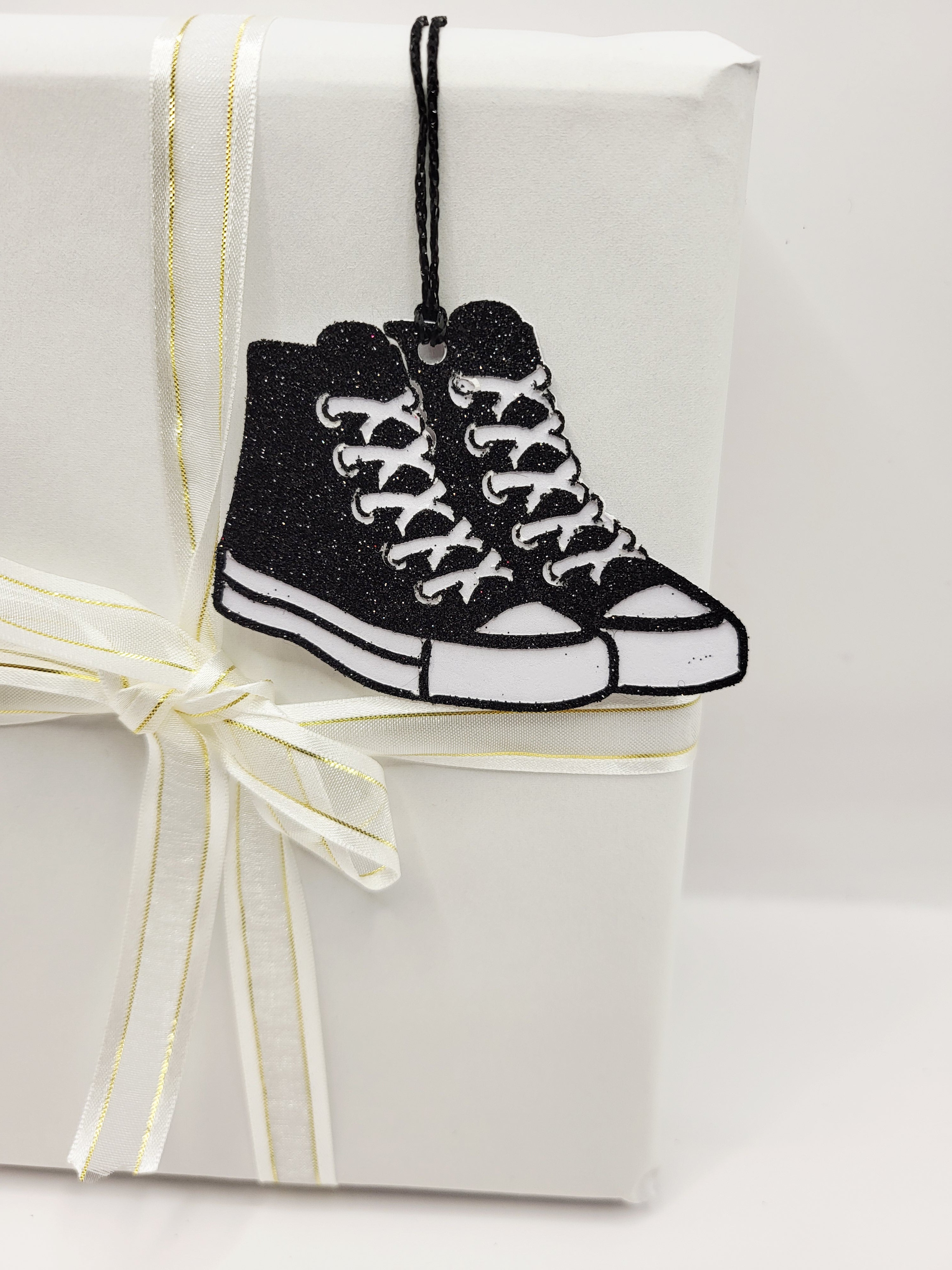 Black glitter baseball boots with a white background. \there is a black metallic cord to attach to your gift