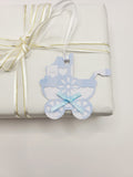 Pram shaped gift tag in blue gingham  on a white background. Pram has a blue bow and a white satin ribbon to attach the tag