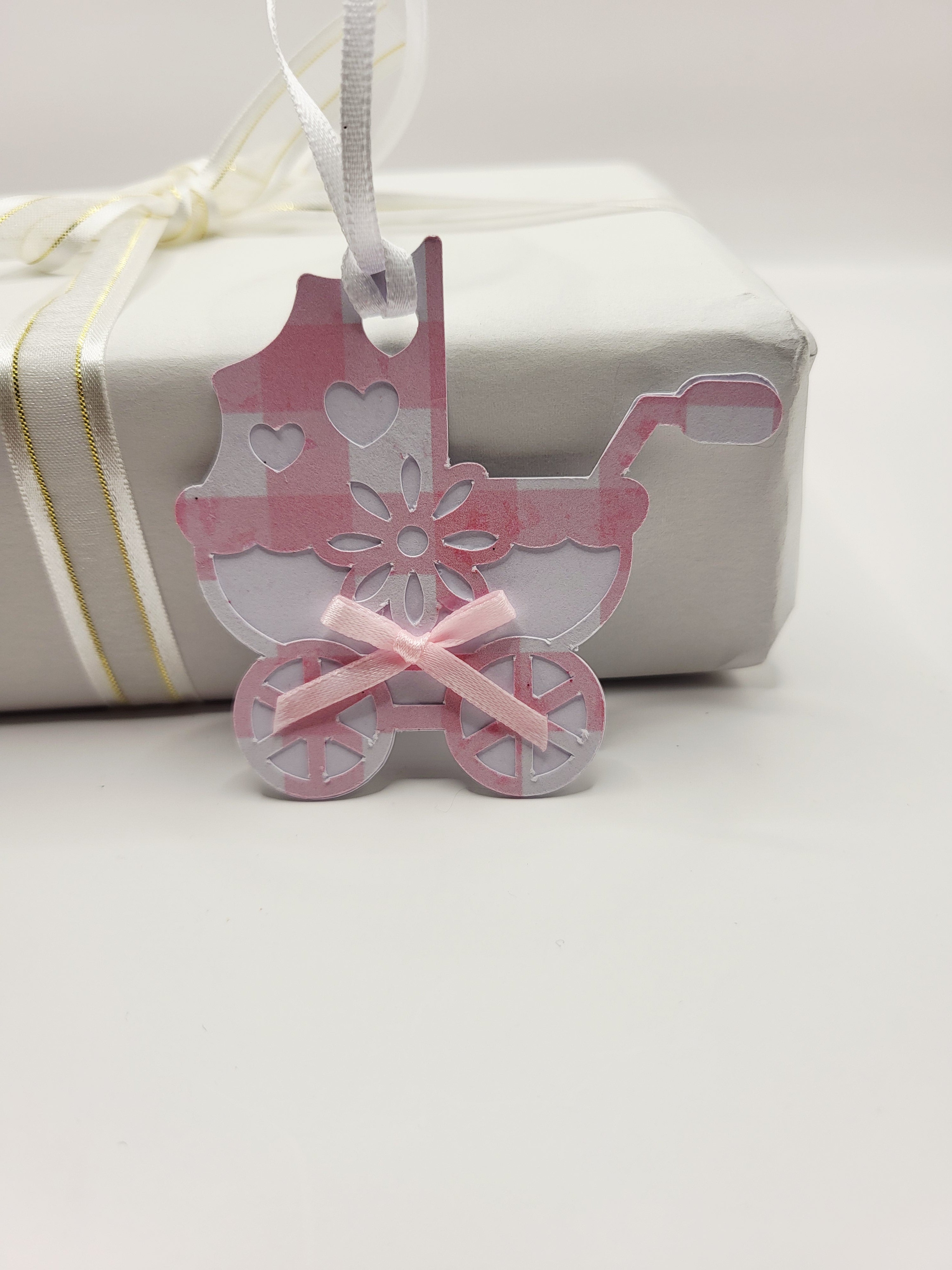 Pink gingham pram shaped gift tag. This tag has a pink bow, and a white satin ribbon to attach to your gift
