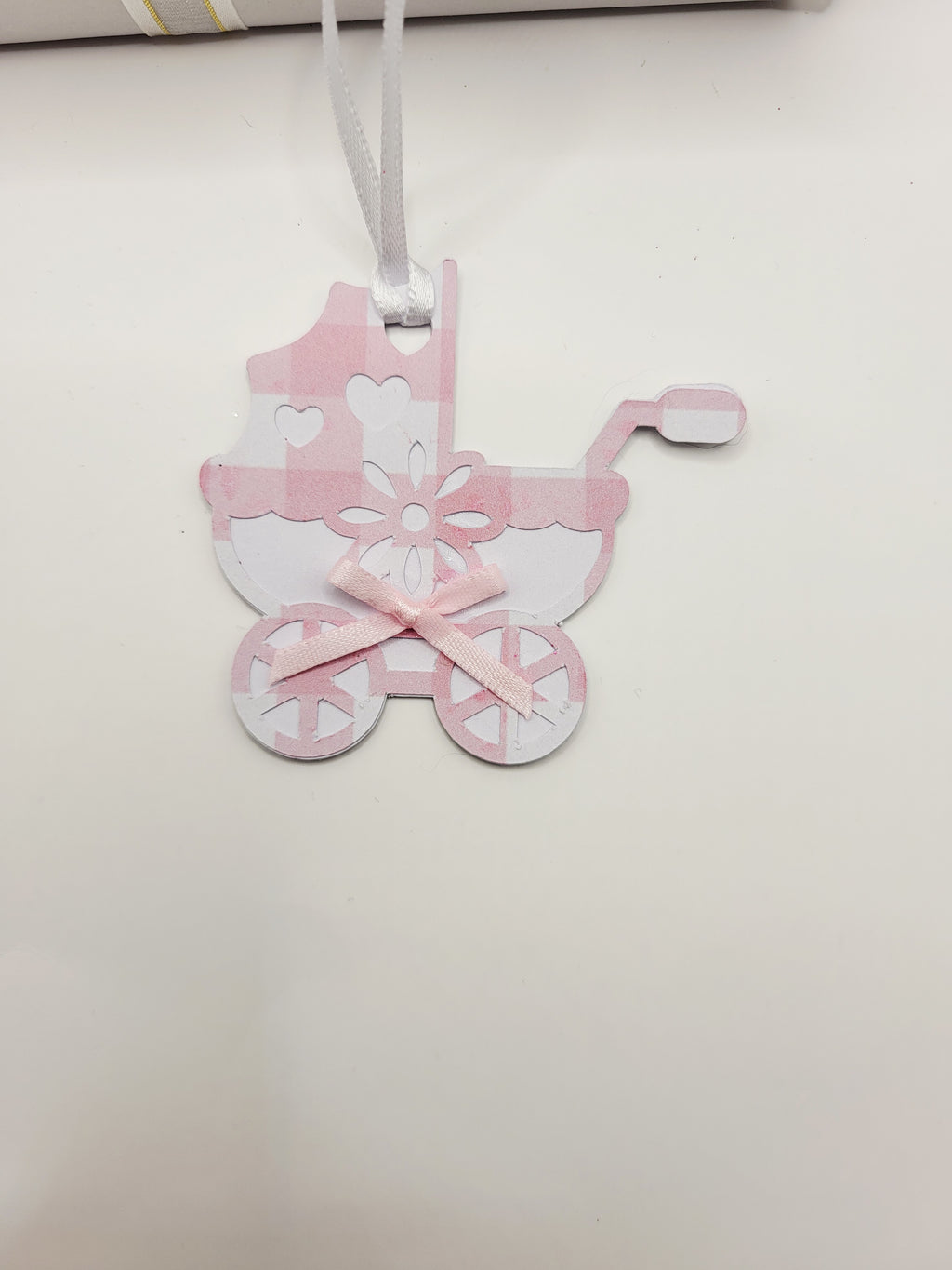 Pink gingham pram shaped gift tag. This tag has a pink bow, and a white satin ribbon to attach to your gift