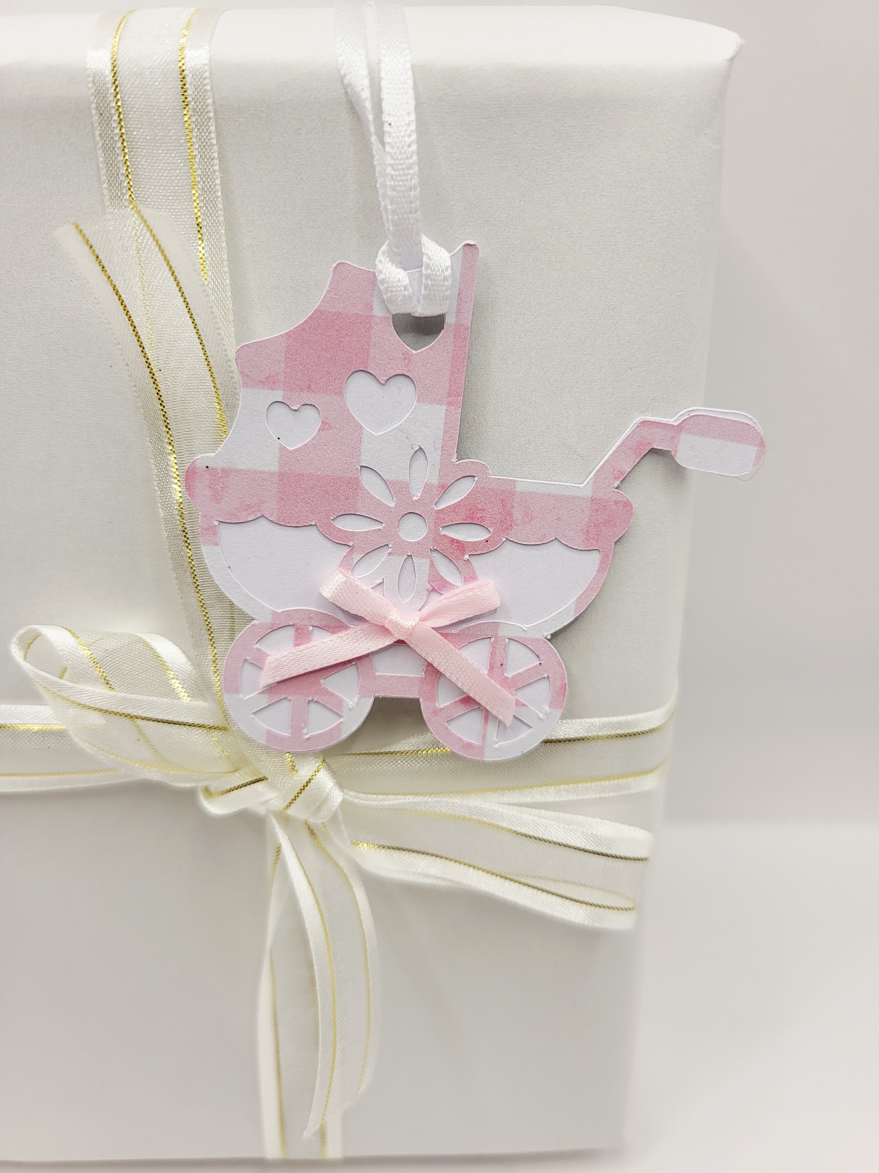 Pink gingham pram shaped gift tag. This tag has a pink bow, and a white satin ribbon to attach to your gift