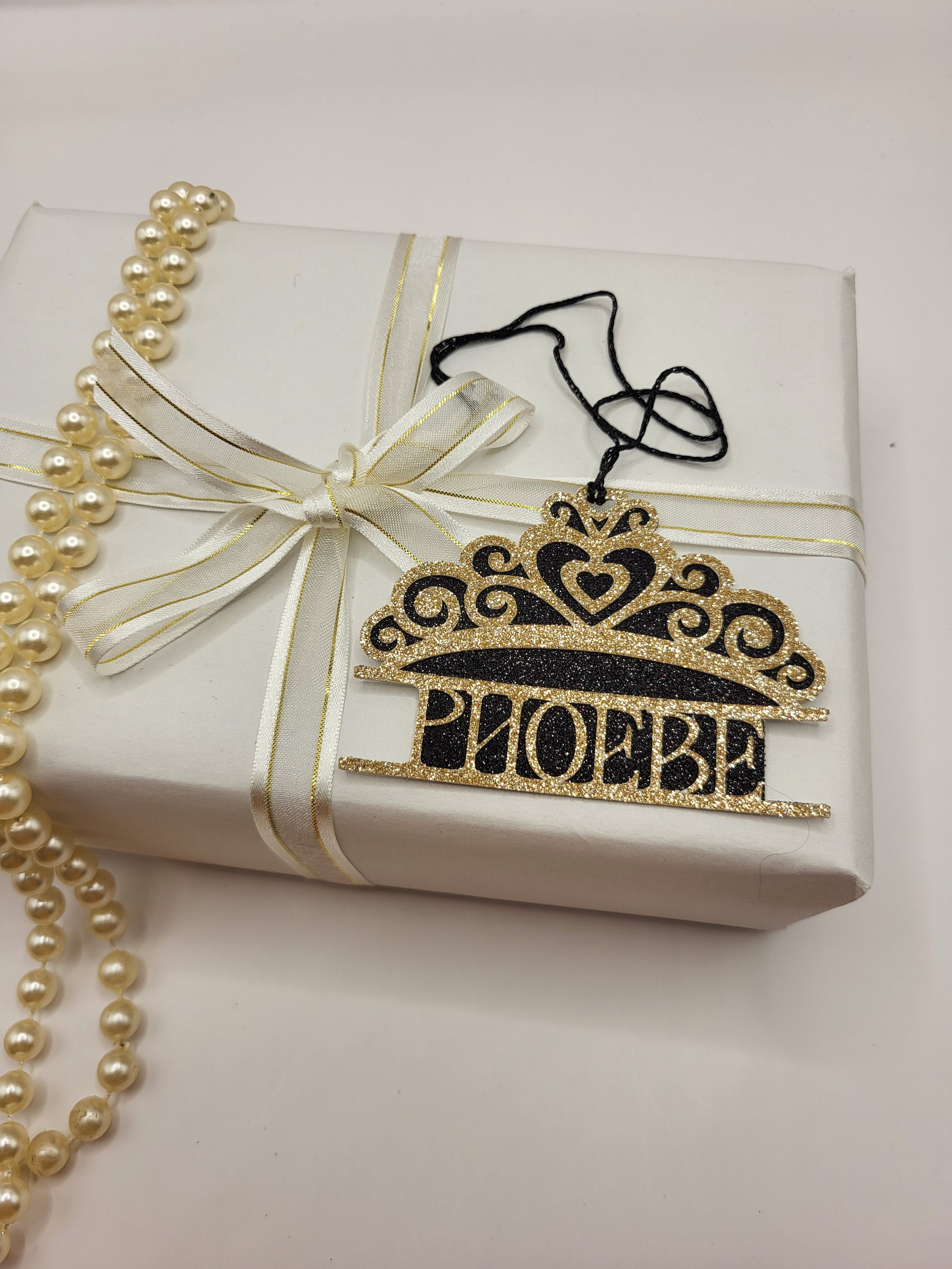Tiara shaped gift tag is gold glitter card on black glitter card and can be personalised. The tag has a black metallic cord  to enable you to attach to a gift