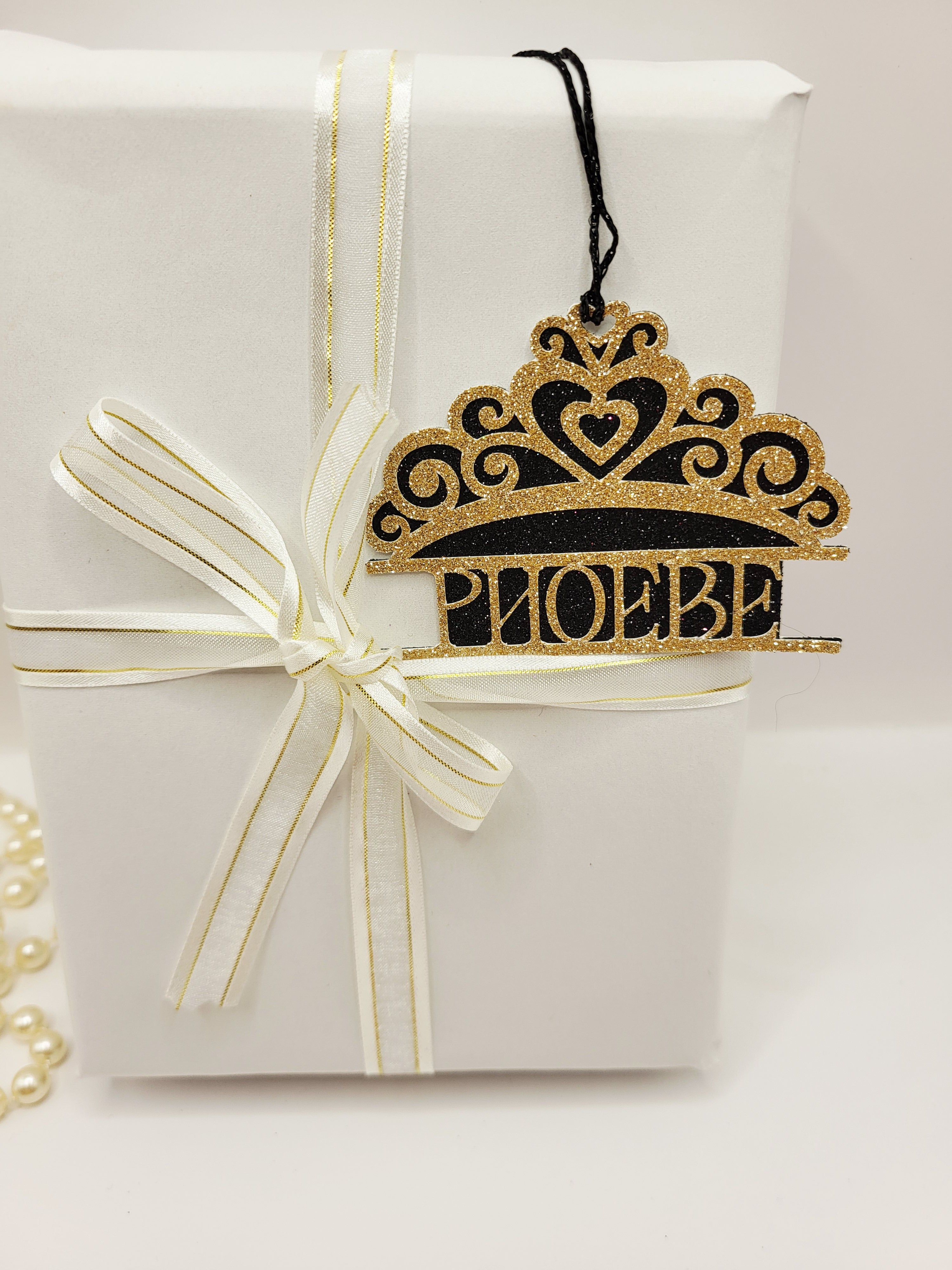 Tiara shaped gift tag is gold glitter card on black glitter card and can be personalised. The tag has a black metallic cord  to enable you to attach to a gift