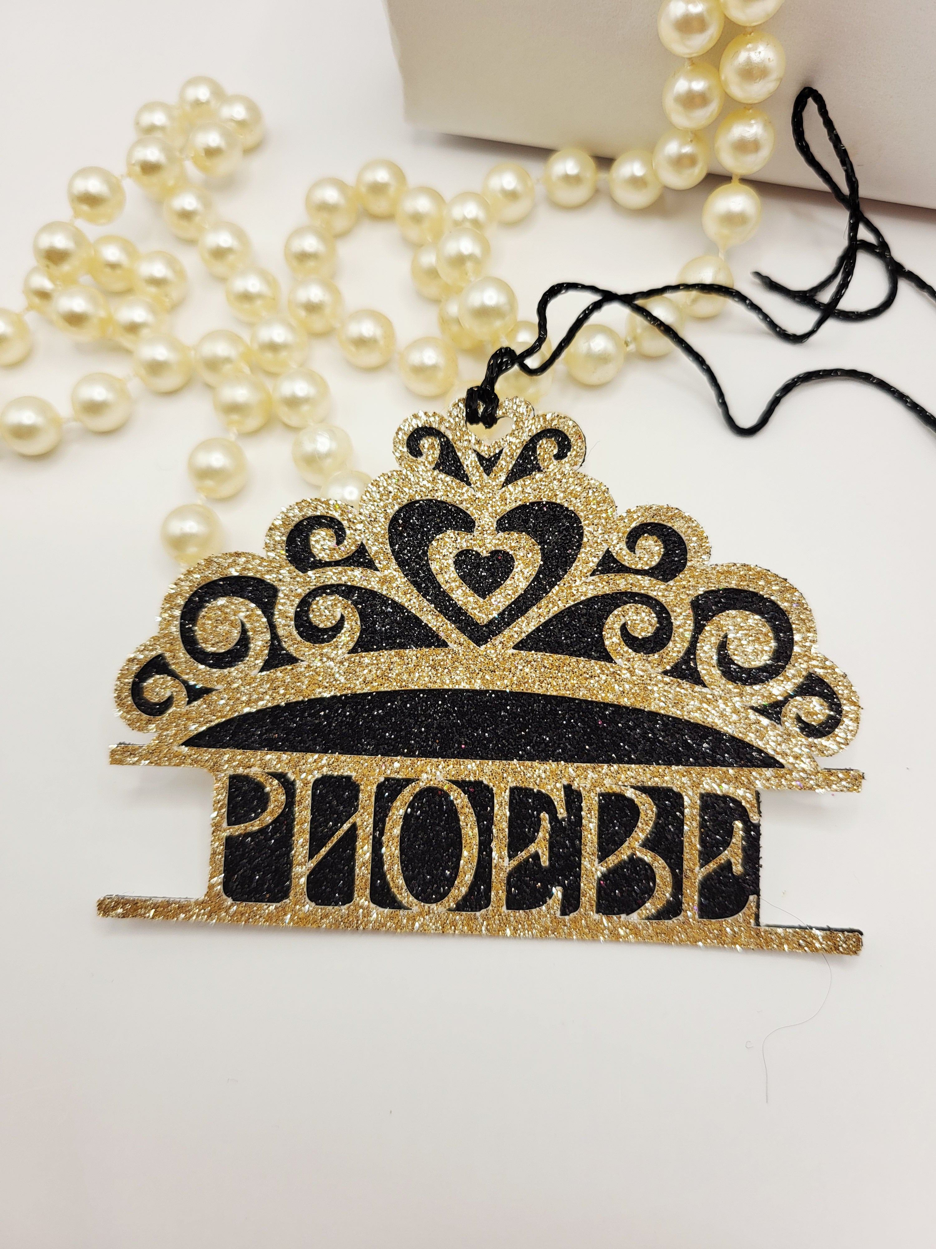 Tiara shaped gift tag is gold glitter card on black glitter card and can be personalised. The tag has a black metallic cord  to enable you to attach to a gift