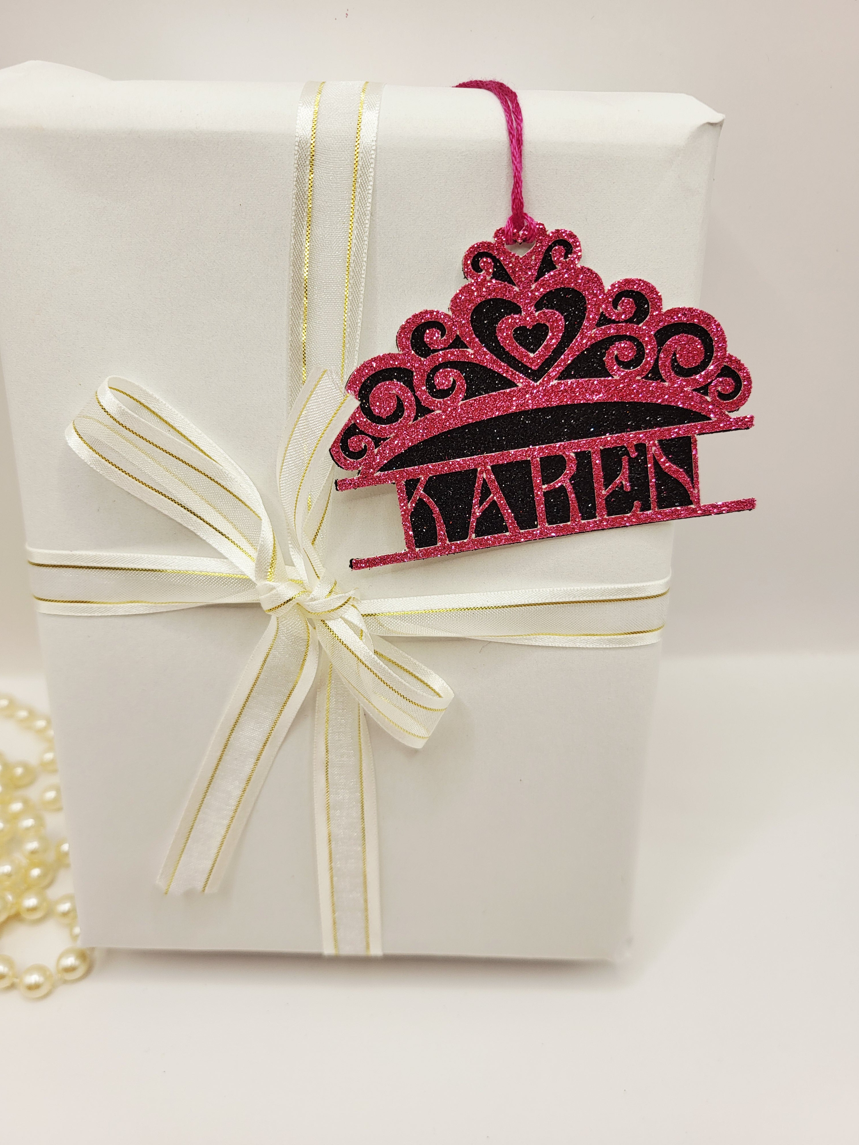 Tiara shaped gift tag is pink glitter card on black glitter card and can be personalised. The tag has a pink silk cord  to enable you to attach to a gift